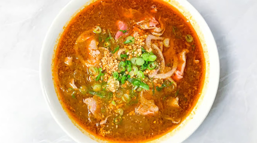 Spicy Beef Sate Pho with Peanuts / Pho Tai Sate Spicy. Peanut based soup with slices of rare steak (please specify if you want it well done). Garnished with white onions, green onions, & cilantro. Comes with beansprouts, basil, and lemon on the side.